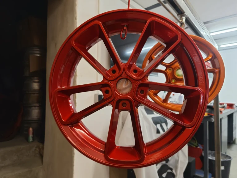 Beschichtete rote und orangefarbene Felgen in der Werkstatt