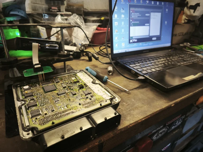 Geöffnetes Steuergerät am Programmierplatz mit Laptop